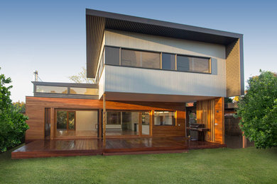 Design ideas for a mid-sized contemporary two-storey exterior in Melbourne with mixed siding and a flat roof.