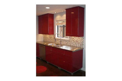 Eat-in kitchen - mid-sized contemporary galley concrete floor eat-in kitchen idea in Atlanta with an integrated sink, flat-panel cabinets, red cabinets, stainless steel countertops, beige backsplash, ceramic backsplash, stainless steel appliances and no island