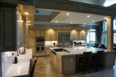 Huge minimalist l-shaped travertine floor and multicolored floor open concept kitchen photo in Las Vegas with an undermount sink, raised-panel cabinets, beige cabinets, quartzite countertops, white backsplash, stainless steel appliances, an island and white countertops