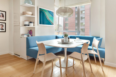 Example of a trendy light wood floor and beige floor dining room design in New York with white walls