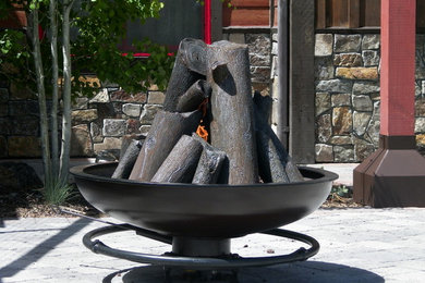 Steel cauldron fire pit with sculpted steel logs