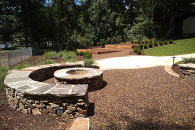This is an example of a mid-sized rustic full sun backyard gravel landscaping in Atlanta with a fire pit.