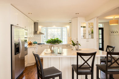 Eat-in kitchen - mid-sized french country l-shaped dark wood floor and brown floor eat-in kitchen idea in Toronto with an undermount sink, shaker cabinets, white cabinets, quartz countertops, white backsplash, ceramic backsplash, stainless steel appliances, an island and white countertops