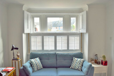 This is an example of a beach style living room in Dorset with white walls.