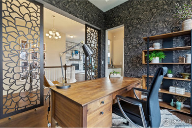 Example of a mid-sized trendy freestanding desk medium tone wood floor and wallpaper home office design in Denver