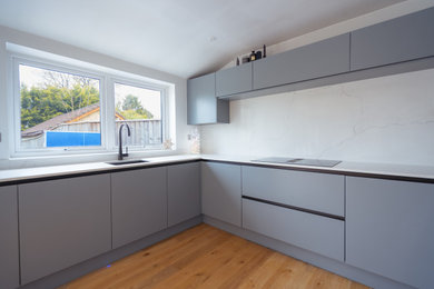 Design ideas for a modern kitchen in Gloucestershire with white splashback, engineered quartz splashback and white worktops.