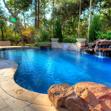 Natural Pool with rock waterfall, bridge, spa, and pergola