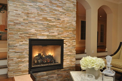 Example of a large transitional enclosed medium tone wood floor living room design in Ottawa with beige walls, a standard fireplace and a stone fireplace
