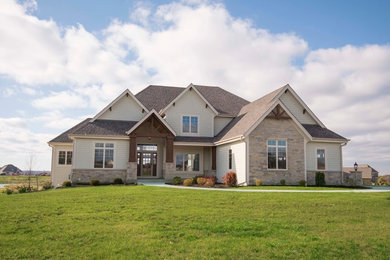 Inspiration for a large timeless beige two-story mixed siding house exterior remodel in Milwaukee with a hip roof and a shingle roof