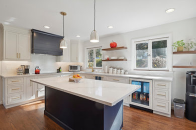 Inspiration for a mid-sized mid-century modern galley dark wood floor and brown floor eat-in kitchen remodel in Wilmington with a drop-in sink, flat-panel cabinets, blue cabinets, quartz countertops, white backsplash, ceramic backsplash, stainless steel appliances, an island and white countertops