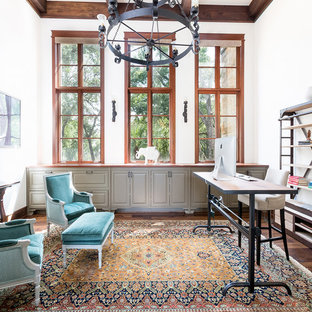 Design ideas for a mediterranean home office and library in Austin with white walls, medium hardwood flooring, a freestanding desk and brown floors.