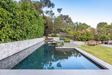 Inspiration for a large backyard custom-shaped infinity pool in Melbourne with with a pool and concrete pavers.