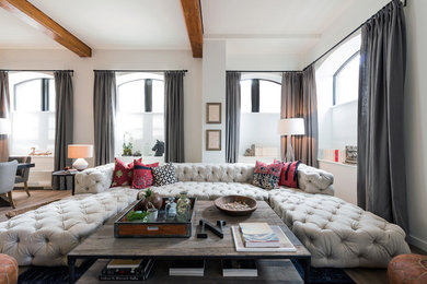 Trendy open concept medium tone wood floor living room photo in New York with beige walls