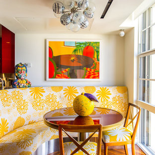 Tropisches Esszimmer ohne Kamin mit weißer Wandfarbe und braunem Holzboden in Miami