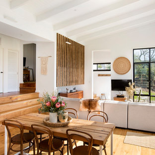 This is an example of a beach style open plan dining in Wollongong with white walls, light hardwood floors, no fireplace and beige floor.