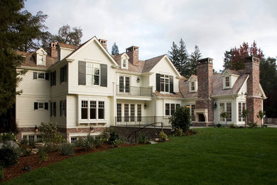Large traditional two-storey white house exterior in San Francisco with a gable roof, concrete fiberboard siding and a shingle roof.
