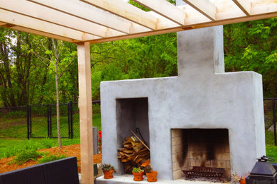 Example of a small trendy front yard concrete paver patio design in Providence with a fireplace and a pergola