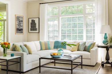Example of a mid-sized classic open concept medium tone wood floor and brown floor family room design in Boston with beige walls