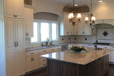 Example of a mid-sized classic galley medium tone wood floor and brown floor eat-in kitchen design in Other with an island, a double-bowl sink, raised-panel cabinets, white cabinets, granite countertops, multicolored backsplash, ceramic backsplash and black appliances