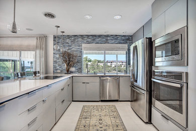 Inspiration for a mid-sized modern u-shaped ceramic tile kitchen pantry remodel in Austin with an undermount sink, gray cabinets, quartz countertops, blue backsplash, matchstick tile backsplash, stainless steel appliances, a peninsula and flat-panel cabinets