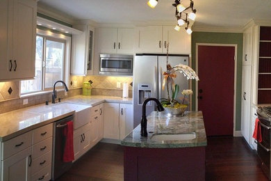 Example of a mid-sized transitional u-shaped dark wood floor and brown floor eat-in kitchen design in San Francisco with a farmhouse sink, shaker cabinets, white cabinets, quartzite countertops, beige backsplash, travertine backsplash, stainless steel appliances, an island and beige countertops