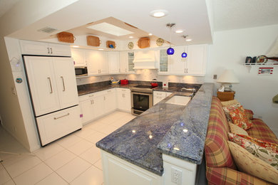 Inspiration for a mid-sized contemporary u-shaped open concept kitchen remodel in Miami with a drop-in sink, raised-panel cabinets, white cabinets, granite countertops, white backsplash, ceramic backsplash, white appliances and a peninsula