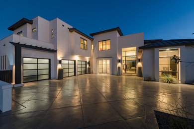 Example of a large trendy white two-story stucco exterior home design in Austin with a metal roof
