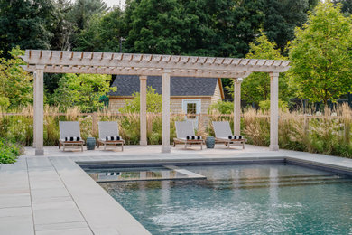 Large elegant backyard stone and rectangular pool landscaping photo in Boston