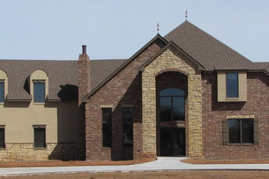 Example of a large classic multicolored two-story brick exterior home design in Oklahoma City with a shingle roof