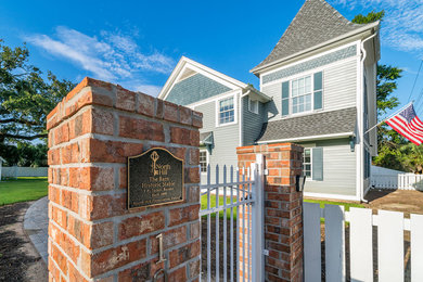 Huge elegant blue two-story wood exterior home photo in Other with a shingle roof