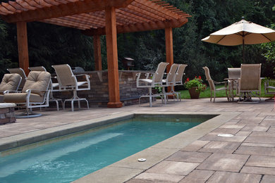 Example of a large backyard concrete paver patio kitchen design in Indianapolis with a pergola