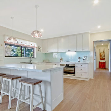 Clean White Shaker Kitchen with breakfast bar and overhead cabinets
