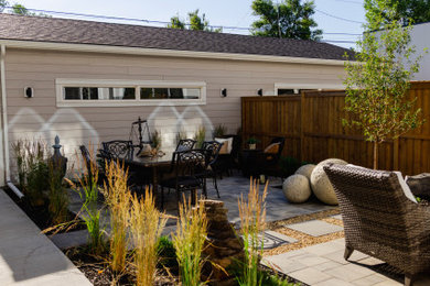 Inspiration for a mid-sized contemporary partial sun backyard concrete paver and wood fence landscaping in Calgary.