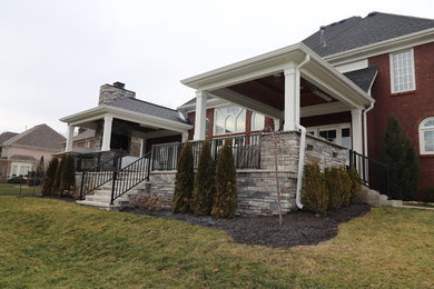 Inspiration for a large timeless backyard concrete paver patio remodel in Louisville with a fireplace and a roof extension