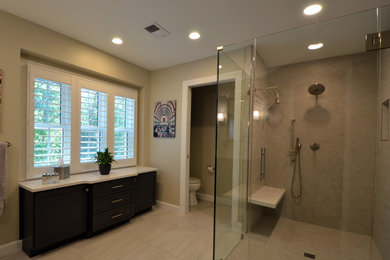 Large classic ensuite bathroom in DC Metro with flat-panel cabinets, grey cabinets, a built-in shower, a two-piece toilet, grey tiles, porcelain tiles, grey walls, porcelain flooring, a submerged sink, engineered stone worktops, grey floors, a hinged door, white worktops, a shower bench, double sinks and a built in vanity unit.