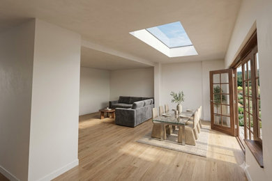This is an example of an open plan dining room in Surrey with beige walls, laminate floors and brown floors.