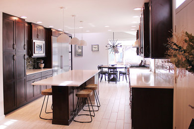 Example of a large trendy galley light wood floor eat-in kitchen design in Other with an undermount sink, recessed-panel cabinets, black cabinets, white backsplash, stainless steel appliances and an island