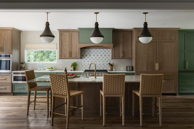 Kitchen - transitional galley dark wood floor and brown floor kitchen idea in Louisville with a farmhouse sink, recessed-panel cabinets, medium tone wood cabinets, gray backsplash, paneled appliances, an island and white countertops