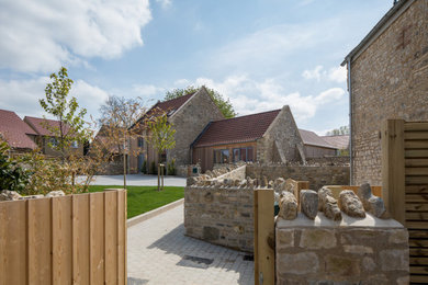 This is an example of a medium sized contemporary two floor detached house in Wiltshire with stone cladding, a pitched roof and a tiled roof.