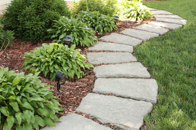 Photo of a mid-sized transitional backyard partial sun formal garden in St Louis with a garden path and natural stone pavers.