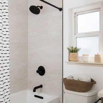 Shower with raised shower head and tub to ceiling wall tile
