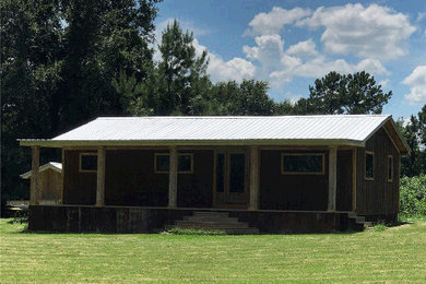 Mid-sized mountain style brown one-story wood exterior home photo in Houston with a metal roof