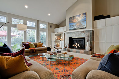 Photo of a large contemporary open concept living room in Dallas with carpet, a standard fireplace, beige walls, a tile fireplace surround, no tv and grey floor.