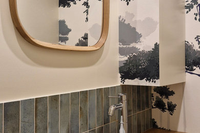 Exemple d'un petit WC suspendu tendance avec un placard en trompe-l'oeil, des portes de placard beiges, un carrelage beige, des carreaux en allumettes, un mur beige, un sol en carrelage de céramique, un lavabo posé, un plan de toilette en bois, un sol beige, un plan de toilette beige et du papier peint.