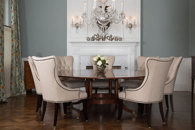 Large elegant medium tone wood floor enclosed dining room photo in Chicago with green walls, a standard fireplace and a wood fireplace surround
