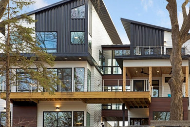 Large trendy white split-level mixed siding house exterior photo in Seattle with a shed roof