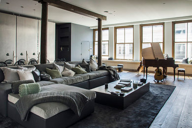 Large trendy loft-style medium tone wood floor living room photo in New York with white walls