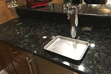 Seated home bar - mid-sized traditional galley porcelain tile and beige floor seated home bar idea in Philadelphia with an undermount sink, raised-panel cabinets, light wood cabinets, granite countertops, black backsplash and stone slab backsplash