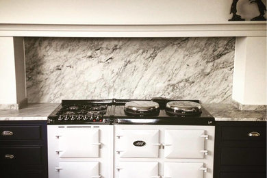 Bild på ett funkis grå grått kök, med blå skåp, marmorbänkskiva, grått stänkskydd och stänkskydd i marmor