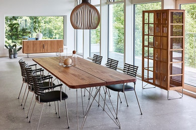 Photo of a contemporary dining room in Paris with white walls, no fireplace and concrete floors.